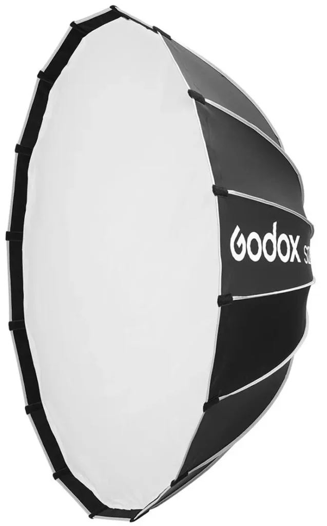 סופטבוקס פרבולי Godox QR-P60T בקוטר 60 ס"מ עם מנגנון Quick Release (שחרור מהיר) חדשני. הפרבוליק יוצר אור עמוק ומנוקד עם ספקולריות חדה – אידיאלי לפורטרטים עם עין-אור מרהיבה. דיפיוזר שקוף חלבי (T=Translucent) ניתן להסרה לחשיפת הרפלקטור הפרבולי הגולמי. מנגנון QR מאפשר פריסה וקיפול תוך שניות בודדות – חוסך זמן יקר בצילומי שטח. תואם הרכבות Bowens עם מתאמים זמינים לרוב הבזקי הסטודיו. בניה מקצועית מחומרי פרימיום, מסגרת אלומיניום קלת משקל.